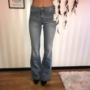  - Ljusa flarejeans med små fickor där fram. Aldrig använda, prislapp finns kvar.