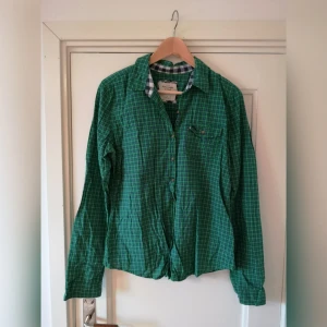  - Grön rutig skjorta. Ganska kort modell. 