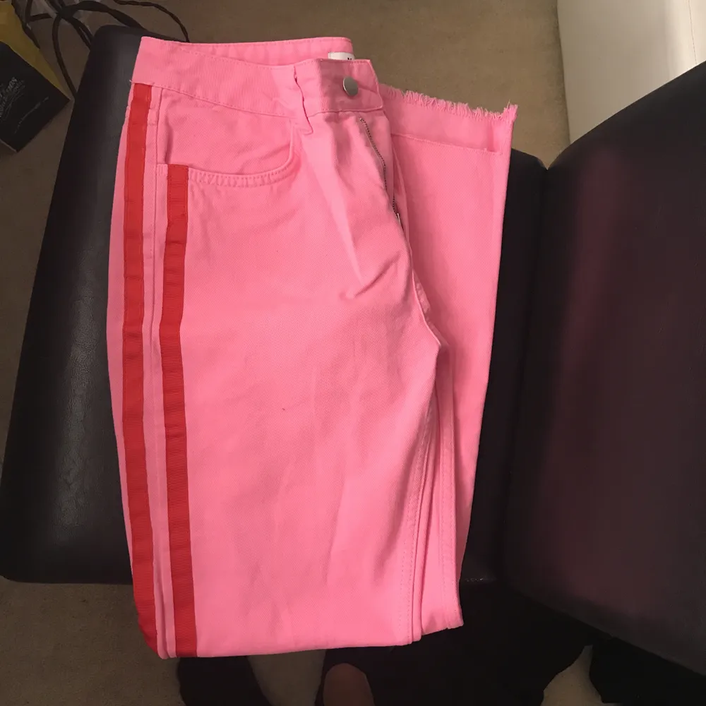 Slutsålda rosa jeans med röd rand från Na-kd! Strl 38, lite mindre i strl så skulle säga mellan 36/38, passar båda storlekarna. Aldrig använda. Supertrendiga & fina detaljer.. Jeans & Byxor.