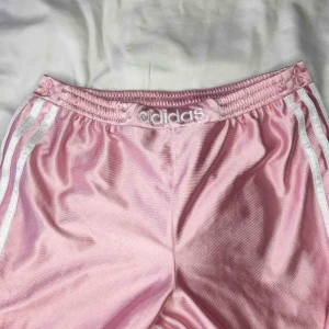  - Så fina rosa adidas-trackpants som tyvärr är för små för mig! Slutar ungefär vid anklarna, knappar längs benen! Superfint skick, finns dock lite ”noppror” på översidan men inget man tänker på. Finns i Malmö eller skickas mot frakt 🌸