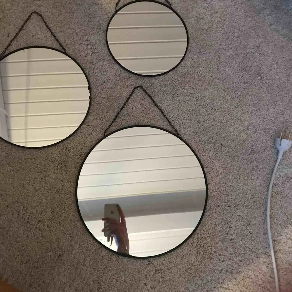 Tre stycken runda speglar, i olika storlekar. Varje spegel har en svart ram och en svart kedja som”krok”. Övrigt.