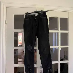 Supersnygga jeans från Hannalicious kollektion med NA-KD. Hög midja och med dragkedja som knäppning. Slitningar på ena knät och längst ner vid fötterna. Frakt tillkommer