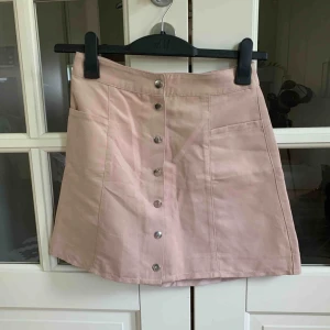  - Högmidjad kjol i mockaimitation med knäppning. Sparsamt använd. Frakt tillkommer