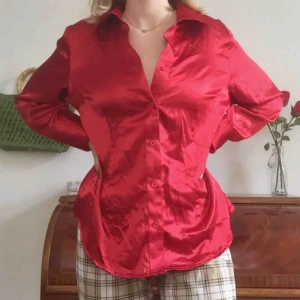  - Härlig röd skjorta i siden-liknande material. Köpt secondhand. Möts endast nära Södermalm. Frakt tillkommer. Skriv om du har frågor.
