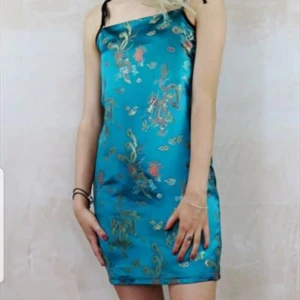  - Slip dress in teal chinese dragon satin. Nyköpt klänning från asos marketplace (yapyap) säljes på grund av fel storlek. Nypris 549 kr.