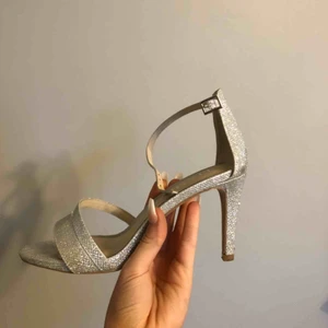 Klackskor - Jättefina silvriga klackar från Tiamo (köpta på Scorett). Använda endast några timmar under en bal. Klackhöjd 9 cm. Nypris: 699 kr.  Kan mötas upp i och runtom Jönköping, annars står köparen för frakt🌸