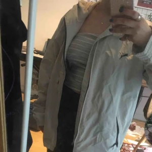  - En vindjacka, beige från märket Puma. Skönt material, i storlek S men är ganska lång. Man kan ha den som en oversize jacka om man är kortare! Inga fel på den! Finns även en luva. Möts upp i Stockholm!