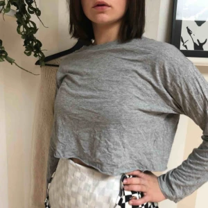  - En grå croppad tröja 