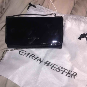  - Carin Wester väska, lackad/vax imitation Jätte fin väska men har helt enkelt inte använt den så mycket. Fint skick och du får även dustbag med:)
