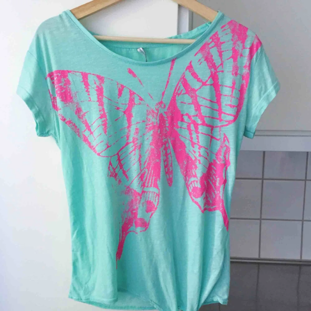 T-shirt med rosa fjäril. Fishbone. T-shirts.