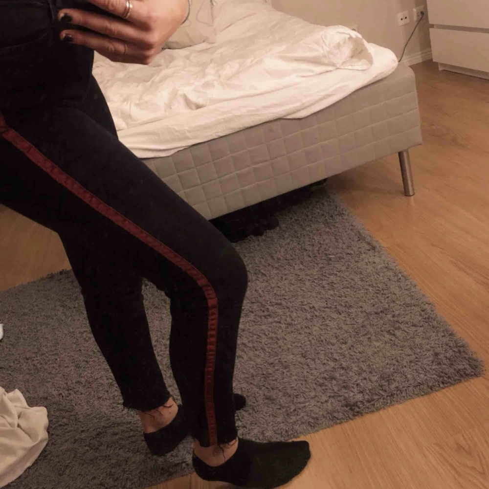 Svarta jeans med lite inslag av grått och röd påsydd linje vid sidorna. Stretchiga trots jeans material. Väldigt sparsamt använda .. Jeans & Byxor.