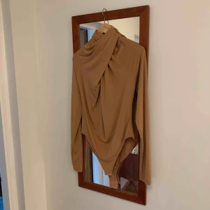  - Guld beige body m drapering i halsen, aldrig använd.