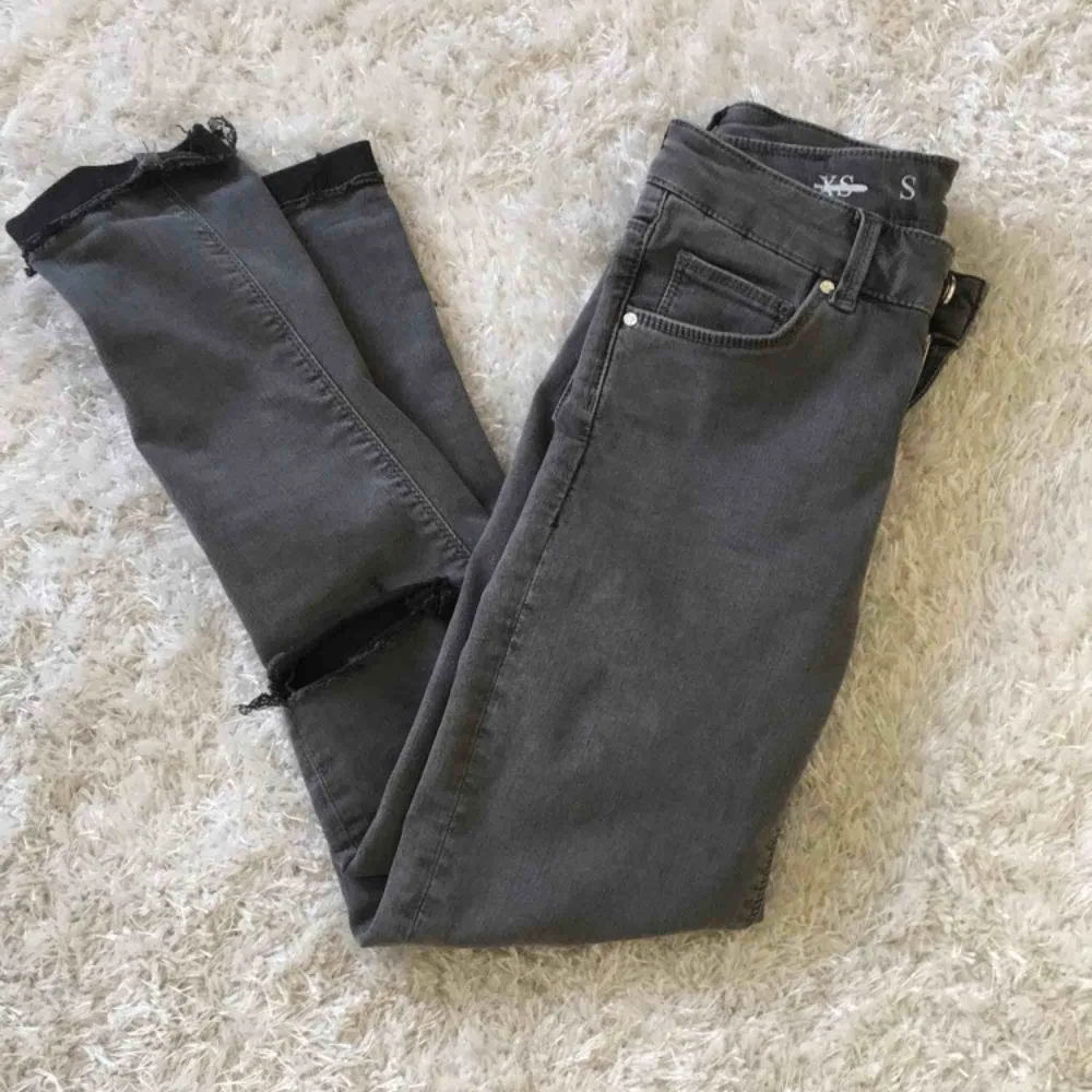 Gråa jeans med slitningar på knäna, står storlek S men passar bättre på någon med xs. Frakten ingår❤️. Jeans & Byxor.