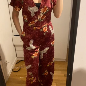 Röd Jumpsuit - Den är lite lång i benen och lite tight i modellen. Har fickor. 