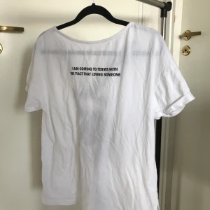 T-shirt storlek 36/38 - Super fin enkel T-shirt med citat och snörning i ryggen, knappast använd. Som ny.  