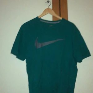 Nike t-shirt - En turkos t-shirt från Nike. Superfin färg och Nikemärket är i en grå färg. Köpt på beyond retro. Väldigt oversized, storlek L