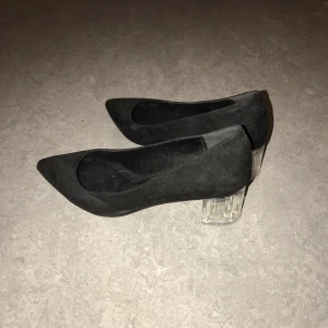 Svarta klackar - Ett par super coola svarta klackskor med genomskinliga klackar. Höger sko har lite skavanker som ni kan se på andra bilden men de är inget man tänker på. Storlek 38. Köpta på Zalando för, minns inte nypriset tyvärr. Väldigt fina, använda vid två tillfällen.