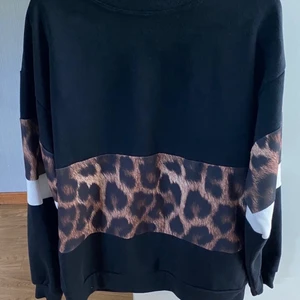 OANVÄND Tröja - Svart tröja med Leopard och vita detaljer.