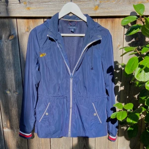 Tommy Hilfinger  - Vårjacka som har ett hyfsat bra skick den har en liten gul fläck på framsidan, som är synligt på första Bilden. Den är väll använd men fortfarande snygg. Är i storlek S, man kan justera på sidorna passformen. Importerad från USA 