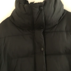 Svart vinterjacka - Svart fluff vinterjacka från Everest i storlek 36. Lång krage så nästan som en Luva. Väldigt mysig till vinter tider. Använd flera gånger men inga problem  på jackan. Frakten står på köparen.