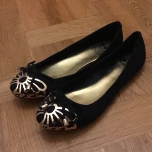 Oanvända skor - Svarta, sammetslil yta med guldmetalldetaljer. Helt oanvända.