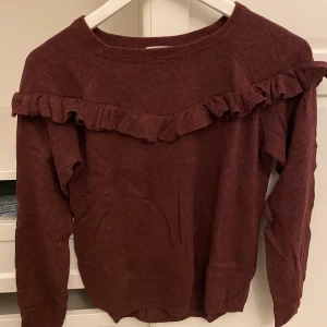 Vinröd blus med volanger  - Köpt från H&M och säljs pågrund av garderob rensning. Använts 2 ggr och är i bra skick. 