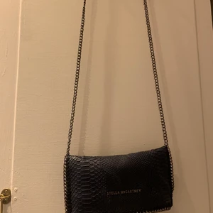 Stella McCartney väska. - Fin väska knappt använd. Äkta. Fina detaljer och man får plats med mycket. Ca 22cm långt. Kedjan har gått av i insidan (se bild). Nypris ca 1,800kr. Om du bor i Stockholm är välkommen att kika på den. Skambuda ej✨