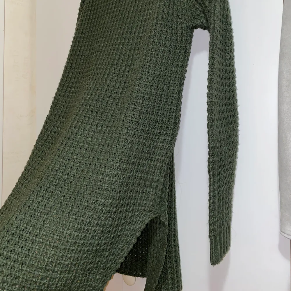En grön, stickad, lite längre tröja från NAKD. Den har en liten slits på varje sida. Använd en gång. Frakt tillkommer💓. Stickat.