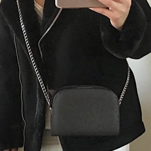 Grå axelväska med kedja  - Super fin Axelväska,  mörkgrå. Finns plats för mobil och nycklar mm. Lätt att styla till olika outfits, Kontakta mig för fler bilder ✨