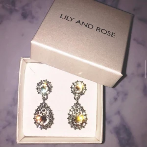 LILY AND ROSE ÖRHÄNGEN - Klassiska Lily and Rose örhängen som tyvärr aldrig kommer till användning. Använda en gång på min bal. Nypris: 500 kr. Priset går att diskutera, örhängena är helt felfria.