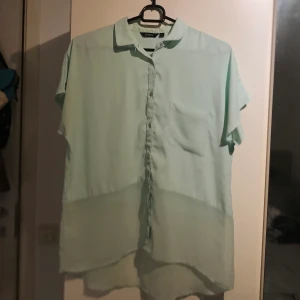 Skjorta i blusform  - Ljusturkos blus som är lite genomskinlig nertill. Storlek XS men passar även S och mindre M. Använd flertalet gånger. Säljes då den inte kommer till användning längre. Köparen står för frakt!