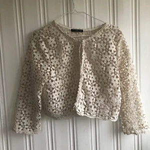 Virkad blus blommor vintage  - Virkad blus/kofta med blommor. Storlek xl men jag har använt den och har varit fint på mig som har xs-s också. 