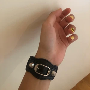 Balenciaga armband  - Super fint armband från Balenciaga i storlek M med endast slitningen ni kan se på andra bilden. Köpt på NK för ca 1500kr. Dustbag och kartong tillkommer.