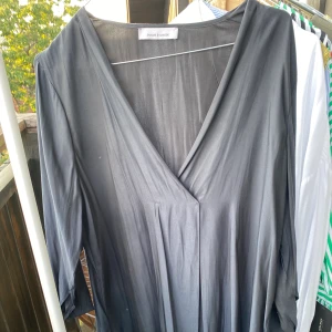 Sidenklänning  - V-ringad klassisk sidenklänningen grå. Fint skick endast använd ett par gånger.  