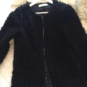  - Svart lurvig jacka med dragkedja 