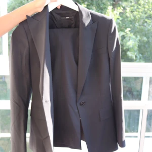 Hugo Boss kostym  - Hugo Boss kostym i storlek S (kavaj + byxor). Aldrig använd, startbud 1200kr
