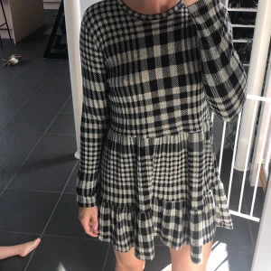 RutMönstrad klänning från Zara  - Rutmönstrad klänning från Zara, svart och vit. Jätte söt/fin modell som sitter bra på de flesta. Lite liten i storleken. Passar till någon under 165 cm, mer som XS pga att den är lite kortare i längden. 