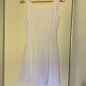 Vit klänning - Super fin vit skolavslutnings klänning. Har en liten fläck på framsidan & en liten på baksidan. Bra skick. Spets på ryggen. Du betalar frakten.