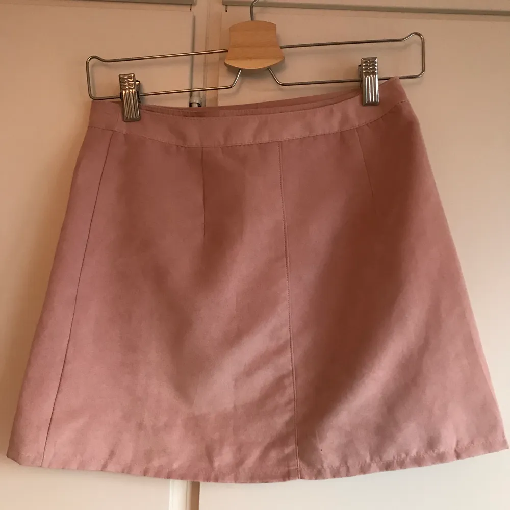 En rosa minikjol i mockaimitation från H&M. Köparen står för frakt. Kjolar.