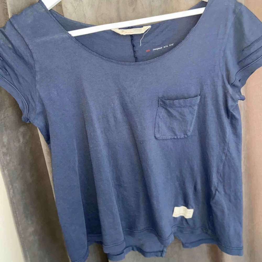 En blå t-skirt med en ficka på bröstet, använd en gång och är verkligen suuuperfin 💕 jag köpte den för ett år sedan för 600kr :). T-shirts.