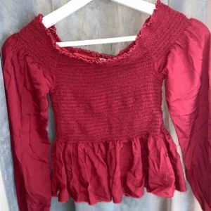  - Vinröd off shoulder topp från USA, den är aldrig använd och fungerar superbra till speciella tillfällen. 
