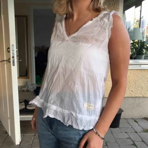  - Ett somrigt vitt linne med fina detaljer!  Ni står för frakten 