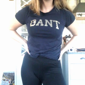  - Mörkblå gant t-shirt med gullig text. Frakt tillkommer 