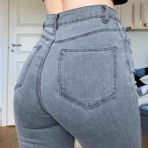  - Högmidjade grå jeans i storlek 34/XS från nakd med hål på knäna! knappt använda så i super fint skick! Du betalar frakten🥰