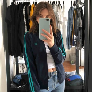 Fred Perry Full Zip  - Fred Perry full zip i mörkblå med turkosa detaljer. Nypris 1000kr. Frakt är inkluderat. Kontakta mig för ytterligare bilder.
