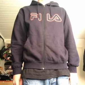  - Mörkblå FILA-ziphoodie i nyskick med tryck över bröstet. Står storlek S men sitter som en M. Sista bilden representerar bäst färgerna.   I priset ingår inte frakt, men kan fraktas om köpare betalar frakt. Kan mötas upp i Åkersberga och Täby. 