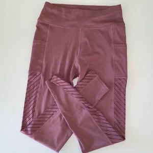 Lila träningstights med fickor - Frakten är inräknad i priset.