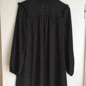 Prickig klänning/tunika - Fin ganska tunn prickig kort klänning med högre krage. Knäpps med knapp i nacken. Som ny