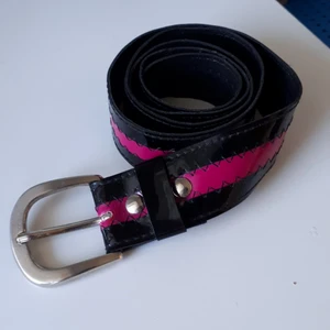 Bälte - Fin svart bälte med rosa detaljer. Fick den second hand, så den är inte i jätte bra skick (bild 2). Frakt tillkommer. 
