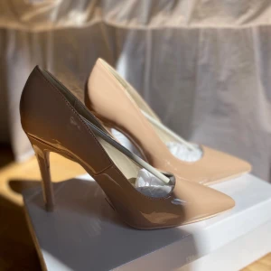 Klackskor  - Säljer oanvända klackskor som är lackade från Nelly. 10cm hög klack, superfina och bekväma. Säljer pga att klacken är för hög. Kan mötas upp i Karlstad annars tillkommer frakt. True to size. Inköpspris: 400kr